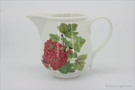 White ceramic pitcher with red berry and green leaf design on a white - Portmeirion - Pomona - Milk Jug (The Red Currant)